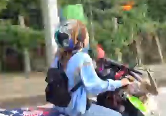 lady rides her skull adorned motorcycle as her pet bird flies alongside 